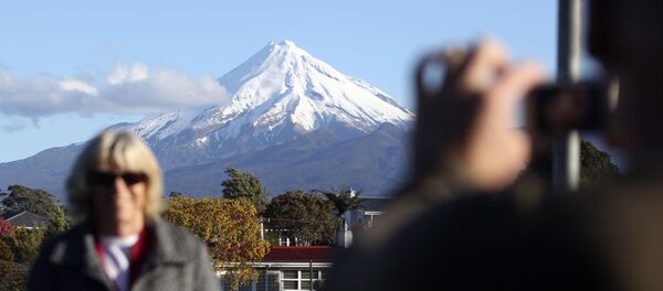Туристка фотографируется на фоне Вулкана Таранаки. Новая Зеландия Туристка фотографируется на фоне Вулкана Таранаки. Новая Зеландия - 俄羅斯衛星通訊社