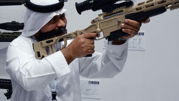 Посетитель осматривает снайперскую винтовку T-5000 российской оружейной компании Орсис (Orsis) на международной выставке вооружений IDEX-2019 в Абу-Даби - 俄罗斯卫星通讯社