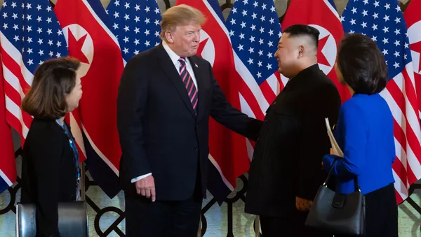 US President Donald Trump (2nd L) speaks with North Korea's leader Kim Jong Un (2nd R) before a meeting at the Sofitel Legend Metropole hotel in Hanoi on February 27, 2019. - 俄羅斯衛星通訊社