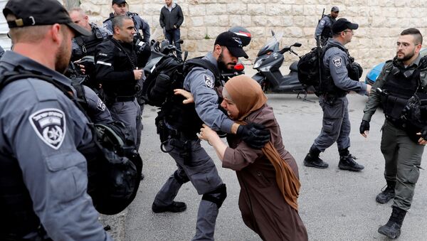 Палестинка пытается прорваться сквозь заслон израильских полицейских после того, как израильские власти закрыли вход на Храмовую гору в Иерусалиме - 俄罗斯卫星通讯社