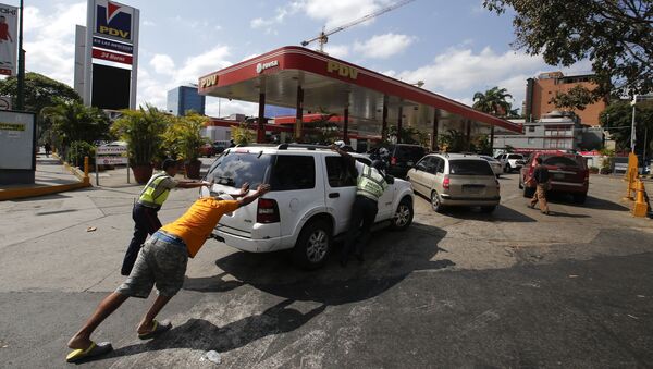 Люди подгоняют машину к заправке, у которой есть собственный электрогенератор, во время перебоев с электричеством в Каракасе, Венесуэла - 俄罗斯卫星通讯社