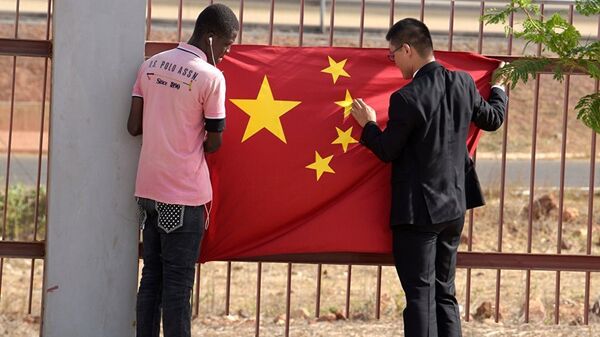 A Senegalese worker and a Chinese man put a Chinese flag in Diamniadio district in Dakar - 俄羅斯衛星通訊社