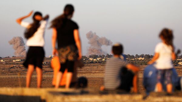 Israeli kids look over the Israeli Syrian border as smoke can be seen following an explosion at its Syrian side it is seen from the Israeli-occupied Golan Heights, Israel July 23, 2018 - 俄罗斯卫星通讯社
