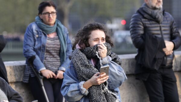 Девушка плачет при виде пожара в соборе Парижской Богоматери - 俄罗斯卫星通讯社