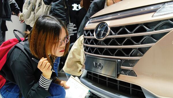 Журналистка смотрит на автомобиль Hyundai Nexo на Шанхайском международном автосалоне - 俄罗斯卫星通讯社