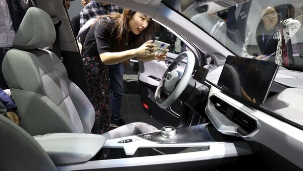 Девушка фотографирует салон автомобиля Geometry компании Geely Auto на Шанхайском международном автосалоне - 俄羅斯衛星通訊社