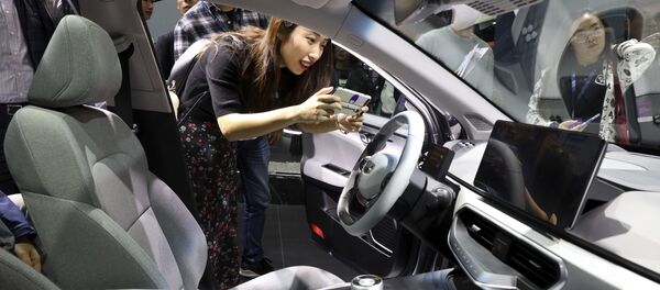 Девушка фотографирует салон автомобиля Geometry компании Geely Auto на Шанхайском международном автосалоне - 俄羅斯衛星通訊社