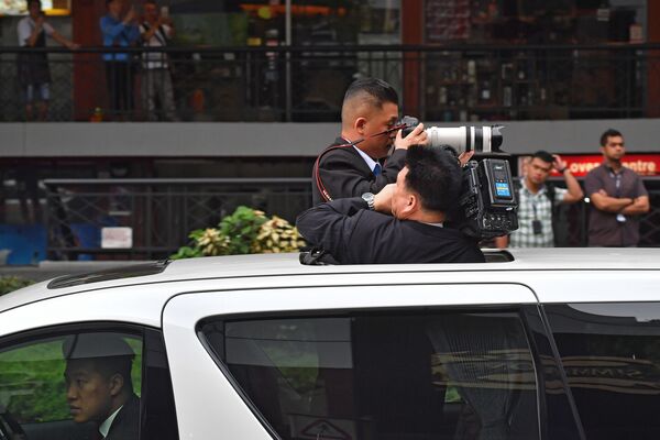 朝鲜领导人金正恩到访新加坡时在一旁拍摄的朝鲜摄影师。 - 俄罗斯卫星通讯社