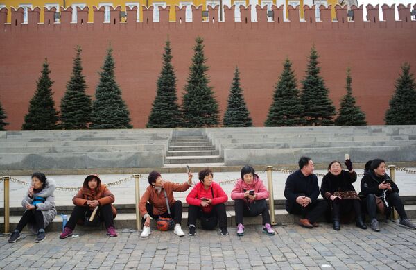 在紅場上克里姆林宮牆邊拍照的遊客們。 - 俄羅斯衛星通訊社