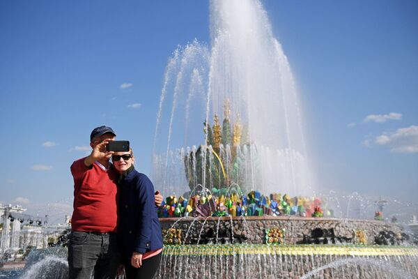 在莫斯科全俄展覽中心已開始工作的“石花“噴泉旁拍照的休閒者。 - 俄羅斯衛星通訊社