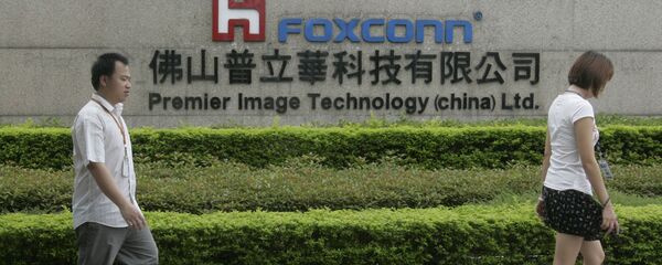 Люди проходят мимо вывески завода Foxconn в Китае Люди проходят мимо вывески завода Foxconn в Китае - 俄罗斯卫星通讯社