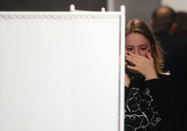 一名女孩在謝列梅捷沃機場為蘇霍伊100型客機的乘客及家屬準備的心理救助室旁 - 俄羅斯衛星通訊社