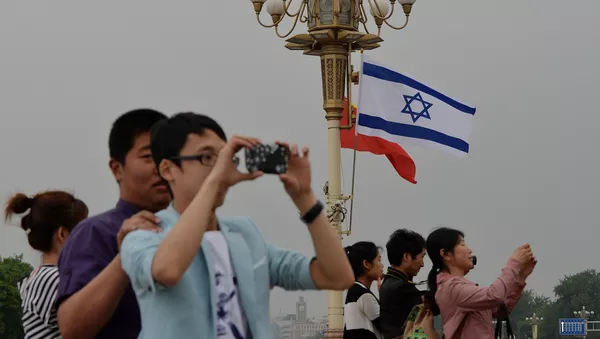 Chinese tourists watch the motorcade of Israeli Prime Minister Benjamin Netanyahu as he arrives to meet the Chinese President Xi Jinping at the Great Hall of the People in Beijing