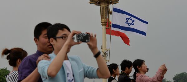 Chinese tourists watch the motorcade of Israeli Prime Minister Benjamin Netanyahu as he arrives to meet the Chinese President Xi Jinping at the Great Hall of the People in Beijing - 俄羅斯衛星通訊社
