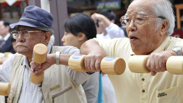 Пожилые люди занимаются с деревянными гантелями в Токио - 俄罗斯卫星通讯社
