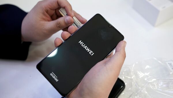 A salesman turns on a new Huawei P30 smartphone for a customer in Beijing - 俄羅斯衛星通訊社