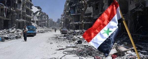 Флаг Сирии в освобожденном лагере палестинских беженцев Ярмук на юге Дамаска.  - 俄罗斯卫星通讯社
