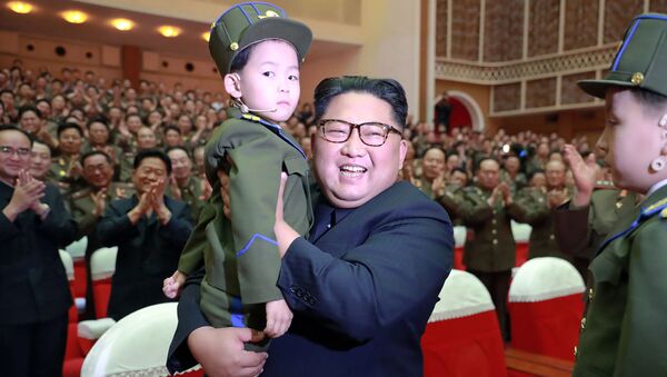 在朝鲜人民军音乐会上， 朝鲜领导人金正恩怀里抱着一个孩子 - 俄罗斯卫星通讯社