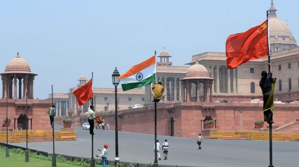 Indian workers tie Indian and Chinese national flags onto poles in front of The Indian Secretariat in New Delhi on May 18, 2013 - 俄羅斯衛星通訊社