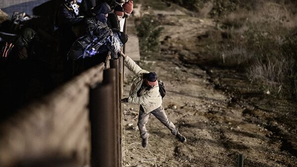 A migrant jumps the border fence to get into the U.S. side to San Diego, Calif., from Tijuana, Mexico - 俄罗斯卫星通讯社