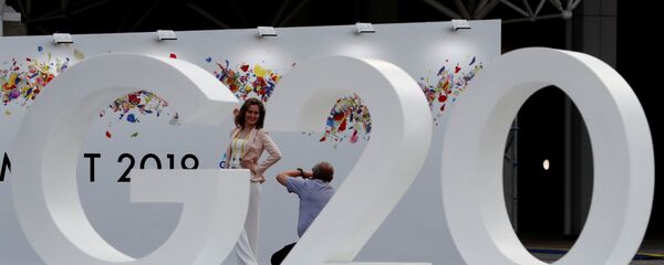 Женщина позирует фотографу у логотипа саммита G20 в Осаке, Япония - 俄罗斯卫星通讯社