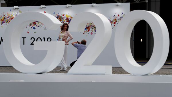 Женщина позирует фотографу у логотипа саммита G20 в Осаке, Япония - 俄罗斯卫星通讯社