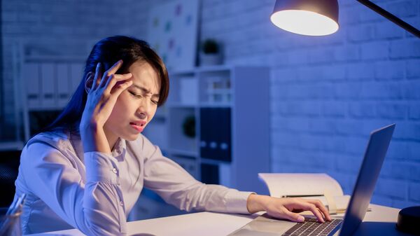 Азиатка страдает от головной боли за рабочим местом перед ноутбуком - 俄罗斯卫星通讯社
