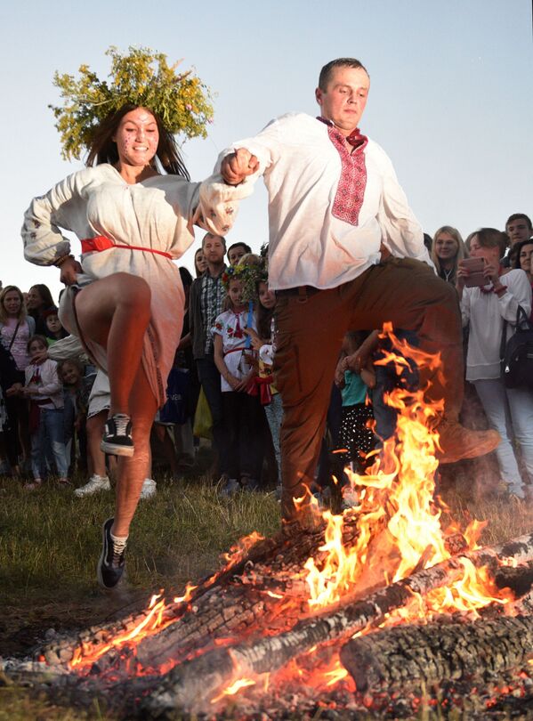 乌克兰小伙和姑娘在伊凡·库帕拉节上跳过篝火 - 俄罗斯卫星通讯社