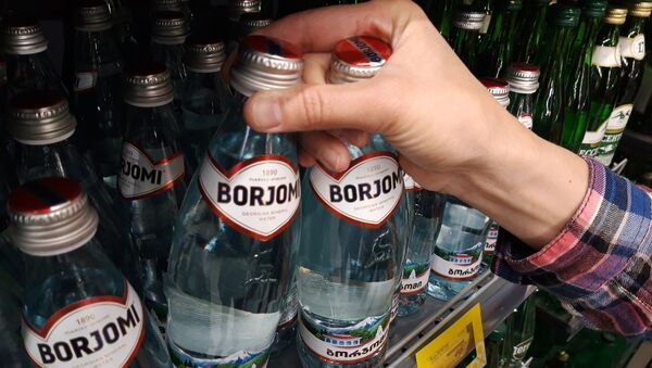 Покупатель берет минеральную воду Боржоми с полки супермаркета - 俄羅斯衛星通訊社