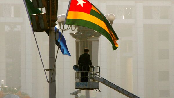A worker prepares the national flags of Tanzania, left, and Togo in Beijing's Tiananmen Square - 俄罗斯卫星通讯社