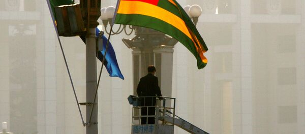 A worker prepares the national flags of Tanzania, left, and Togo in Beijing's Tiananmen Square - 俄罗斯卫星通讯社