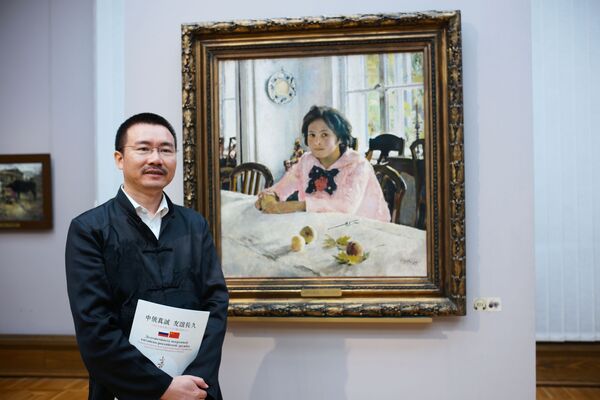 一名中國遊客在特列季雅可夫畫廊畫家謝洛夫的作品《少女和桃子》旁 - 俄羅斯衛星通訊社
