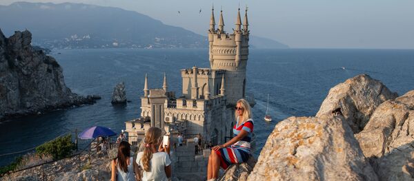 Отдыхающие фотографируются возле замка Ласточкино гнездо на береговой скале в поселке Гаспра в Крыму - 俄罗斯卫星通讯社