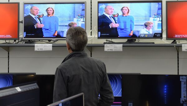 Посетитель магазина смотрит трансляцию ежегодной специальной программы Прямая линия с Владимиром Путиным - 俄羅斯衛星通訊社