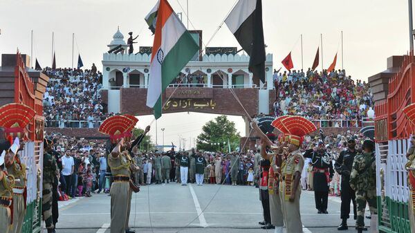 Индийские и пакистанские флаги опускаются во время ежедневной церемонии отступления на совместном контрольно-пропускном пункте Индия-Пакистан на границе Аттари-Вага около Амритсара, Индия - 俄羅斯衛星通訊社