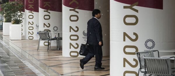 Мужчина на фоне баннеров с символикой Олимпиады-2020 в Токио - 俄羅斯衛星通訊社