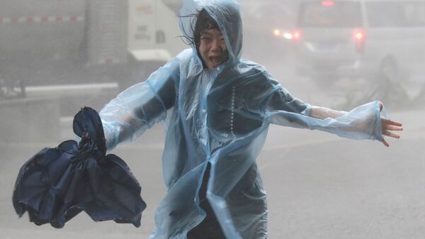 Женщина под проливным дождем, вызванным тайфуном Мангхут, Китай - 俄罗斯卫星通讯社