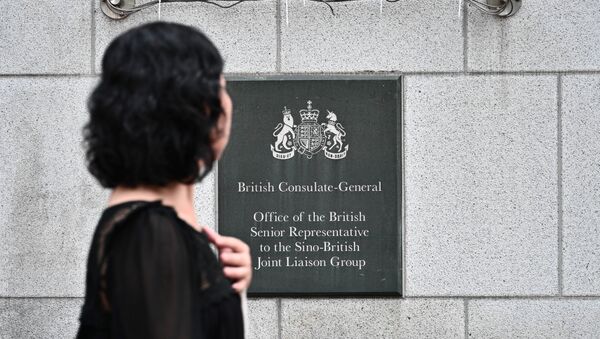 A pedestrian walks past a plaque outside the British Consulate-General building in Hong Kong - 俄罗斯卫星通讯社