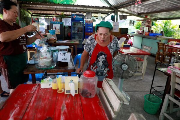 泰國曼谷街頭的商販在看被抓的放到塑料瓶中的眼鏡蛇。 - 俄羅斯衛星通訊社