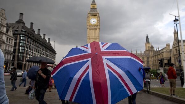 Пешеход с зонтом в цветах британского флага в Лондоне - 俄罗斯卫星通讯社