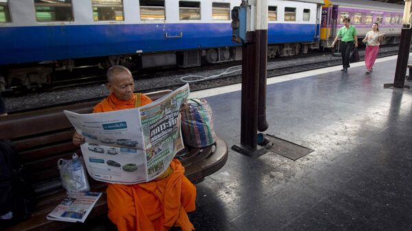 泰國和尚在泰國曼谷華南蓬火車站看報 - 俄羅斯衛星通訊社