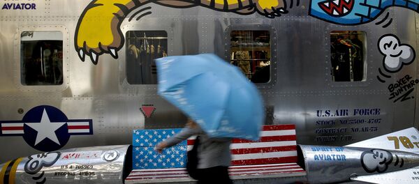 A woman walks by a bench painted with an American flag outside a fashion boutique selling U.S. brand clothing at the capital city's popular shopping mall in Beijing - 俄罗斯卫星通讯社