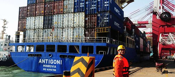 Рабочий на фоне грузового судна в порту Циндао в Циндао, провинция Шаньдун на востоке Китая - 俄羅斯衛星通訊社