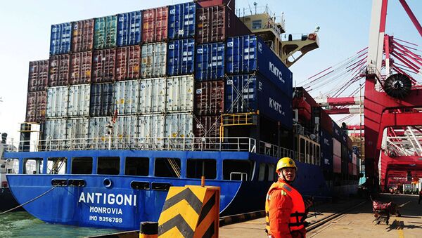 Рабочий на фоне грузового судна в порту Циндао в Циндао, провинция Шаньдун на востоке Китая - 俄羅斯衛星通訊社