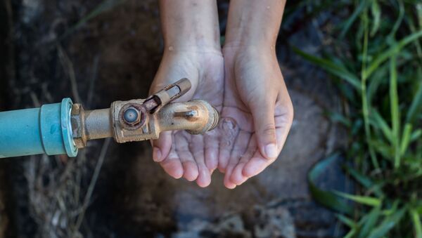 Ребенок протягивает руки к крану с водой - 俄罗斯卫星通讯社