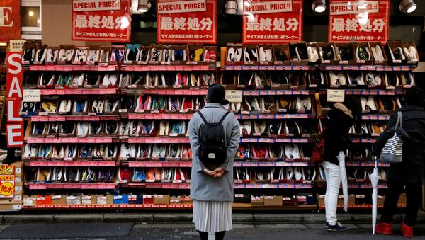 Женщина смотрит на обувь в аутлет-магазине торгового района Токио, Япония - 俄羅斯衛星通訊社