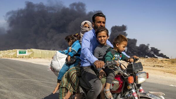 Беженцы на мотоцикле покидают сирийский город Рас-эль-Айн на границе с Турцией - 俄罗斯卫星通讯社