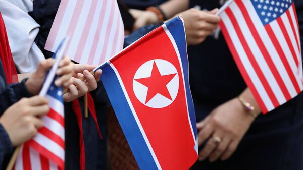 Bystanders holding North Korea and U.S. flags wait for the motorcade of U.S. President Donald Trump in Hanoi - 俄羅斯衛星通訊社