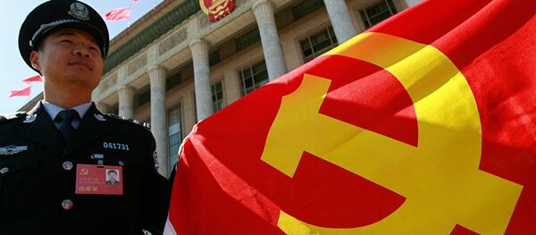 Полицейский держит флаг Коммунистической партии КНР Полицейский держит флаг Коммунистической партии КНР - 俄罗斯卫星通讯社