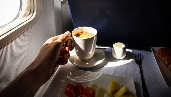 Пассажир с чашкой кофе на борту самолета - 俄羅斯衛星通訊社